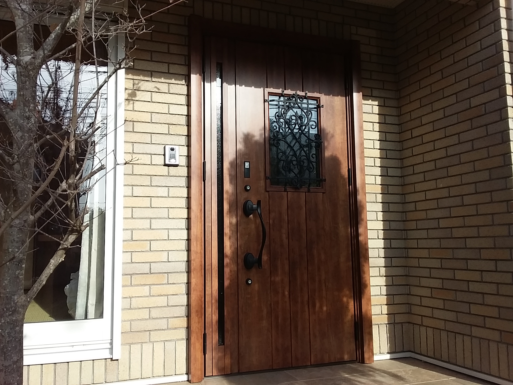 レンガ調の外壁に合う木目のドアにリフォーム Lixilリシェントd41型 埼玉県吉川市の工事事例 玄関ドアリフォームの玄関ドアマイスター