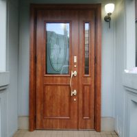 ランマ付きのアルミ色のドアをランマのない木目調のドアにしました【LIXILリシェントC15型】芝山町の工事事例